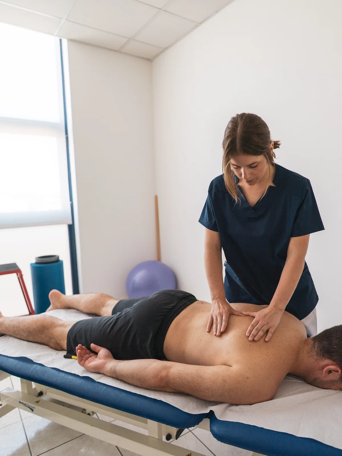 Terapia manuale sulla zona lombare, paziente prono sul lettino